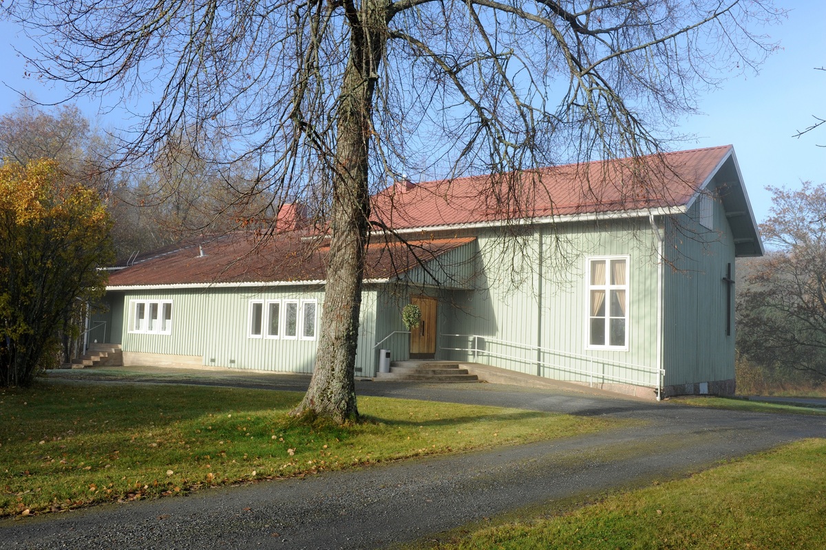 Kemiön seurakuntatalo Kemiön seurakuntakoti, vihreät seinät ja punainen katto, etualalla suuri puu, joka on jo pudottanut lehtensä.